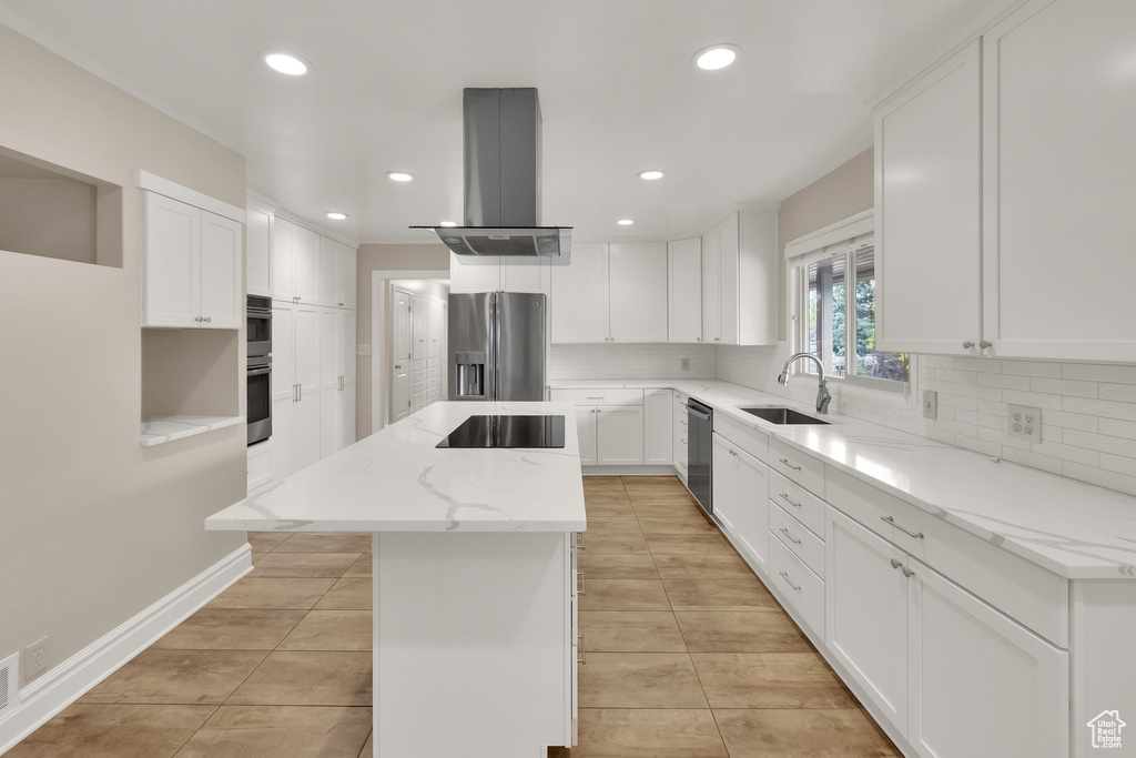 Kitchen featuring stainless steel appliances, a center island, island exhaust hood, a sink, and tasteful backsplash