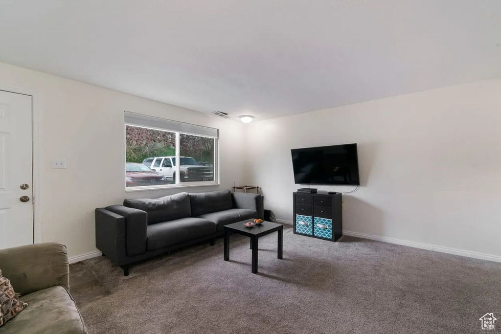 Living area featuring baseboards, visible vents, and carpet