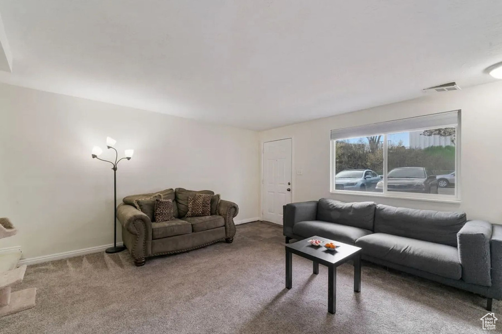 Carpeted living room featuring visible vents and baseboards
