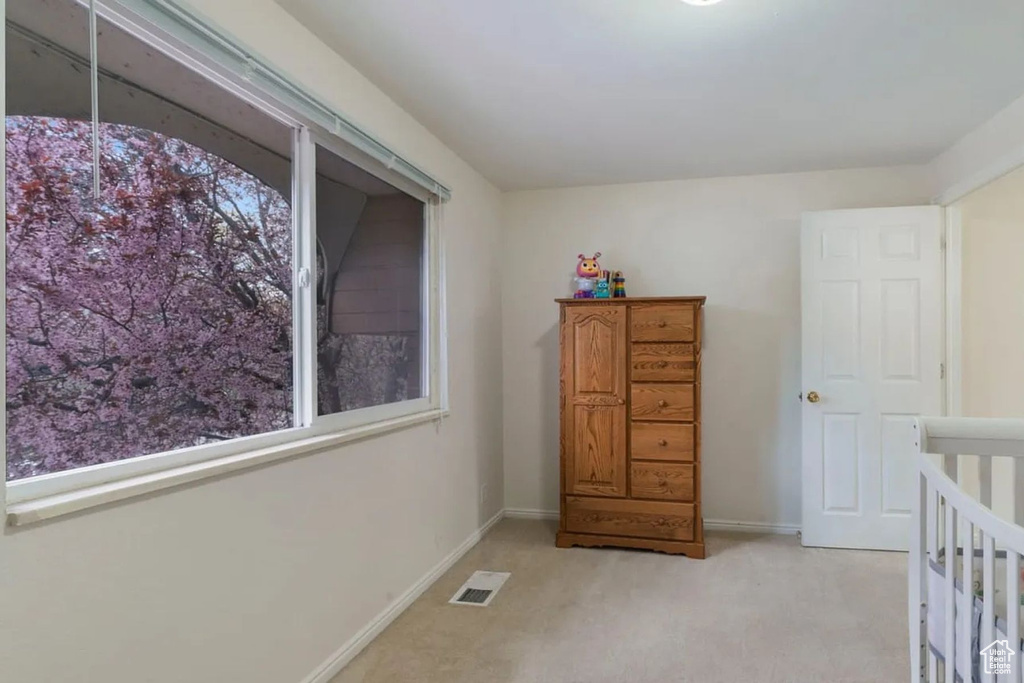 Bedroom with light carpet, visible vents, and baseboards