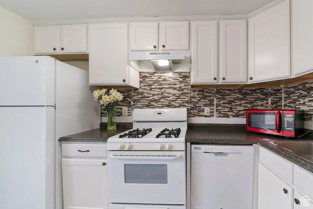 Kitchen featuring white cabinetry, under cabinet range hood, and white appliances