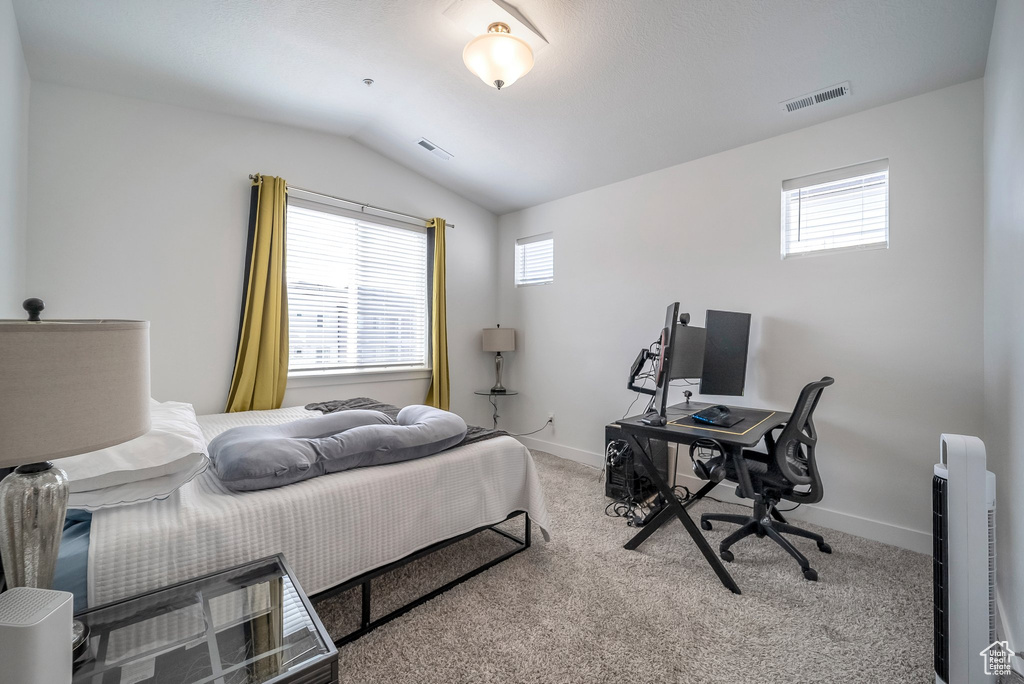 Carpeted bedroom featuring lofted ceiling, baseboards, and visible vents