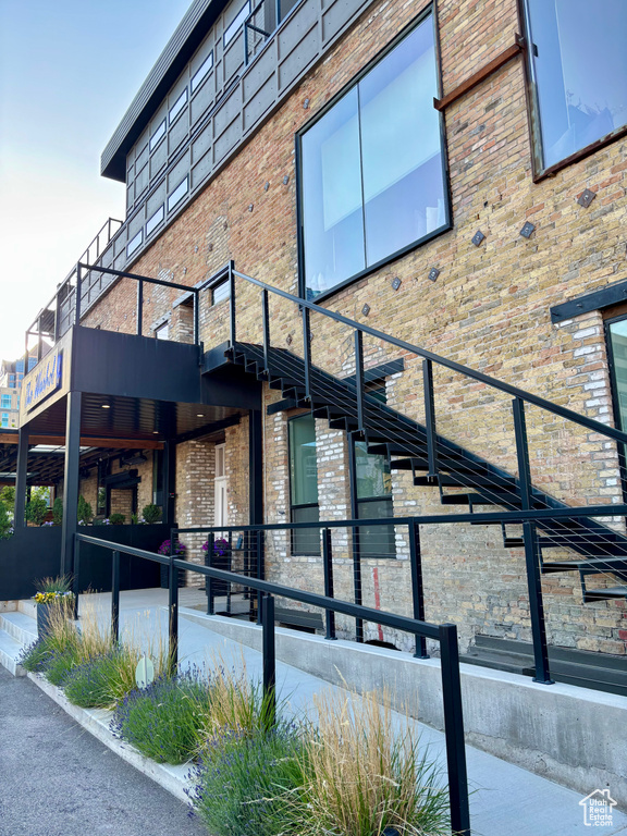 View of side of home featuring brick siding and a balcony
