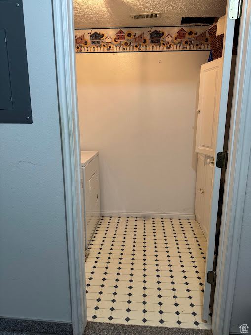 Bathroom featuring electric panel, baseboards, washer and clothes dryer, and tile patterned floors