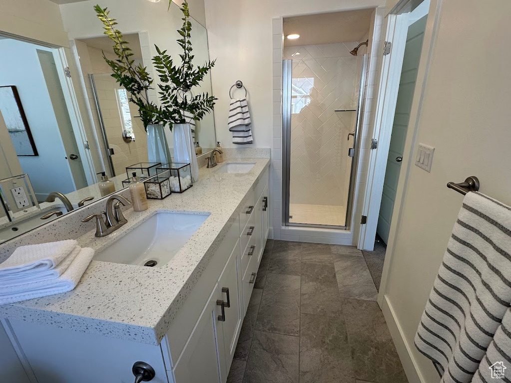 Bathroom featuring stone finish floor, a sink, and a stall shower