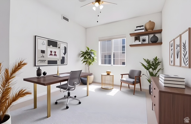 Office space with ceiling fan, visible vents, baseboards, and carpet