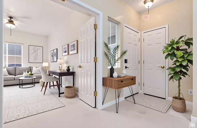 Foyer with ceiling fan and baseboards