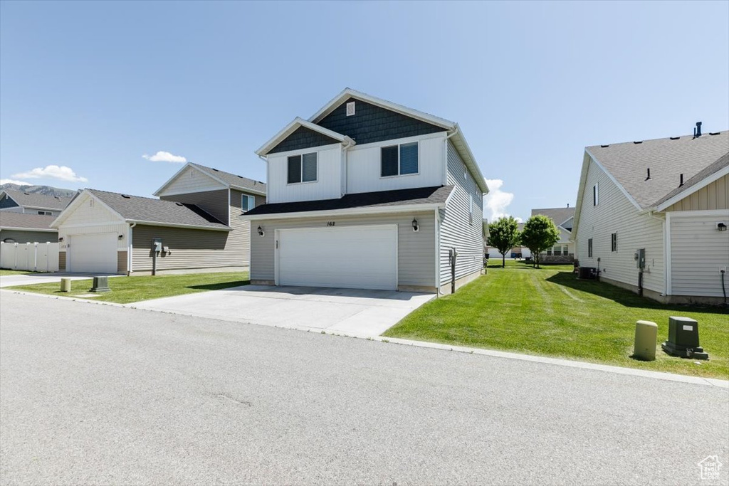 View of front of house with a garage, board and batten siding, driveway, a front lawn, and cooling unit