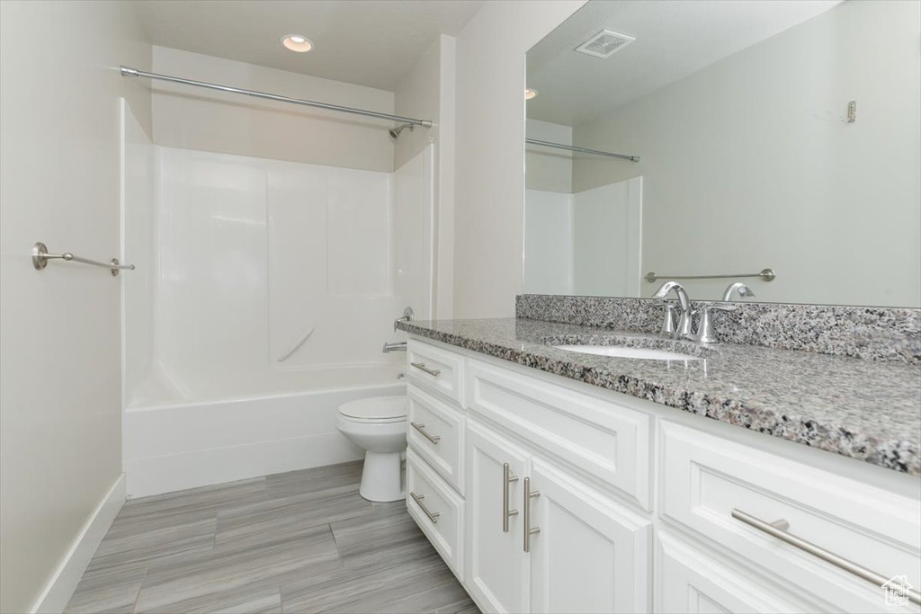 Bathroom featuring vanity, toilet, shower / bathtub combination, recessed lighting, and baseboards