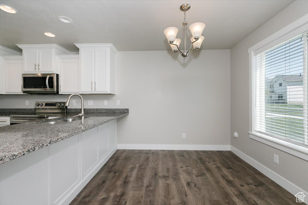 Kitchen with stainless steel appliances, plenty of natural light, baseboards, white cabinets, and recessed lighting