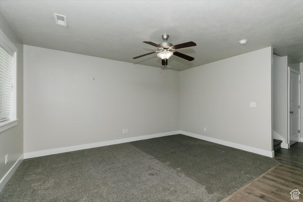 Spare room featuring a ceiling fan, baseboards, plenty of natural light, and a smoke detector