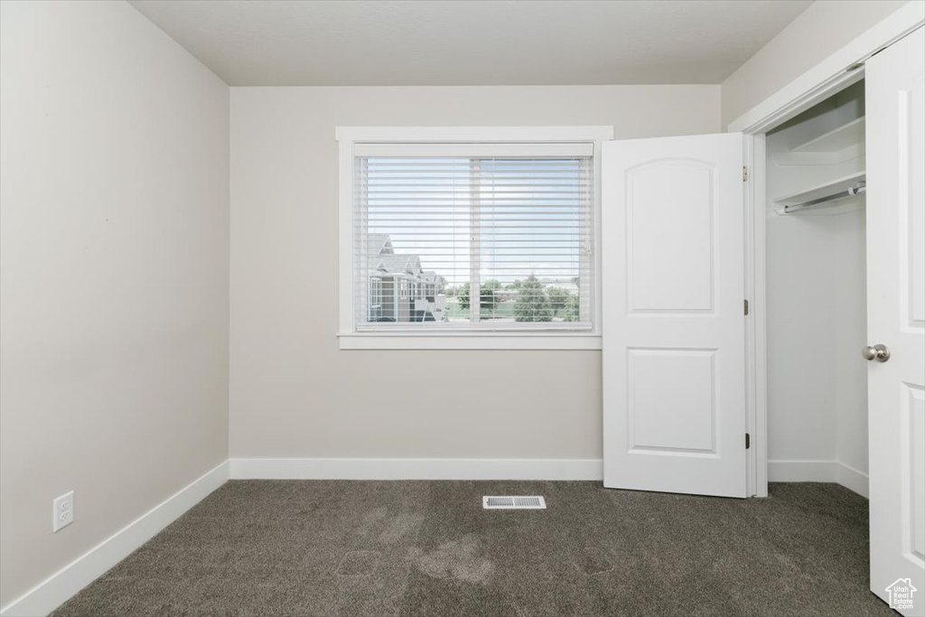 Unfurnished bedroom featuring carpet floors and baseboards
