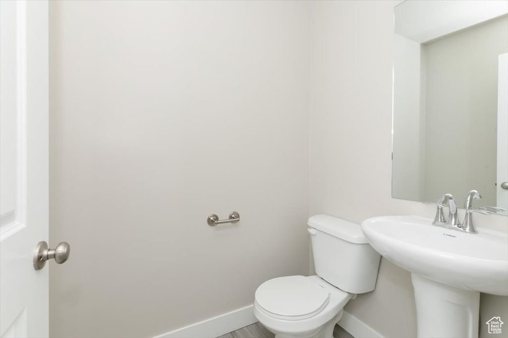 Bathroom with toilet, baseboards, and a sink