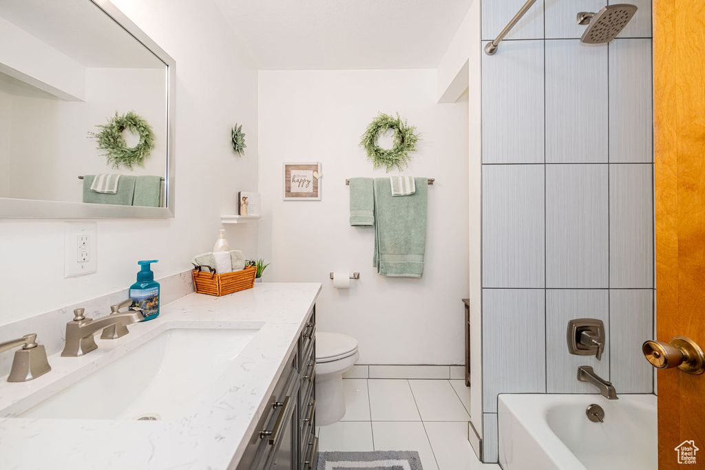 Full bath with vanity, toilet, tile patterned floors, and shower / tub combination