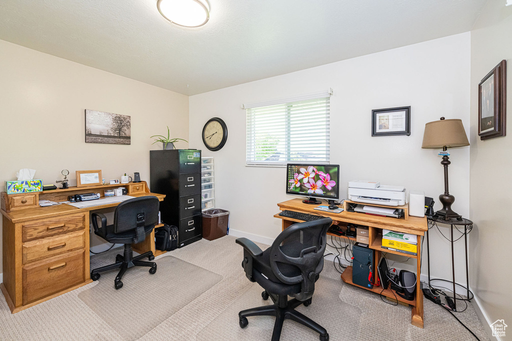 Home office with baseboards and light colored carpet