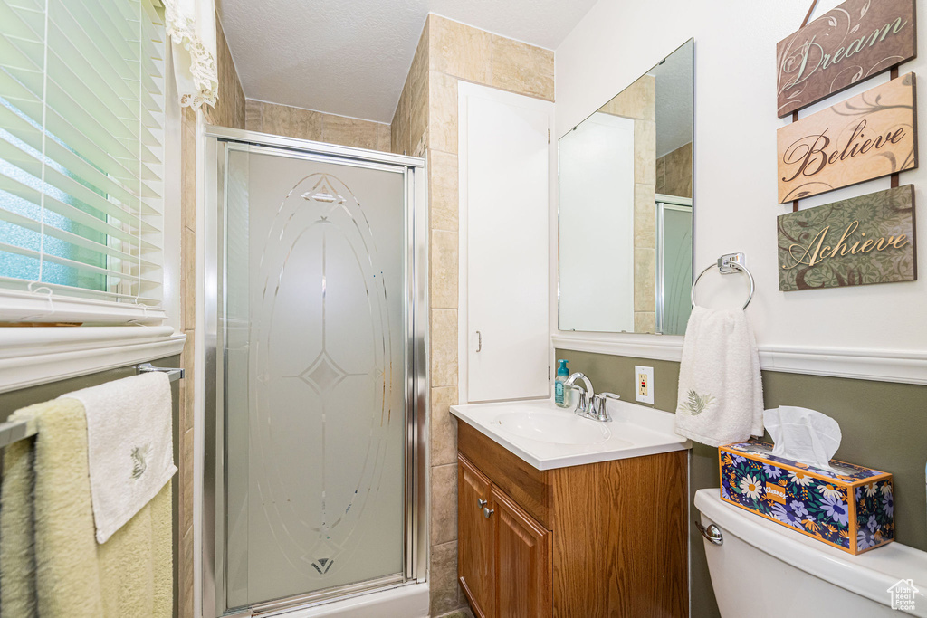 Full bath with vanity, a stall shower, and toilet