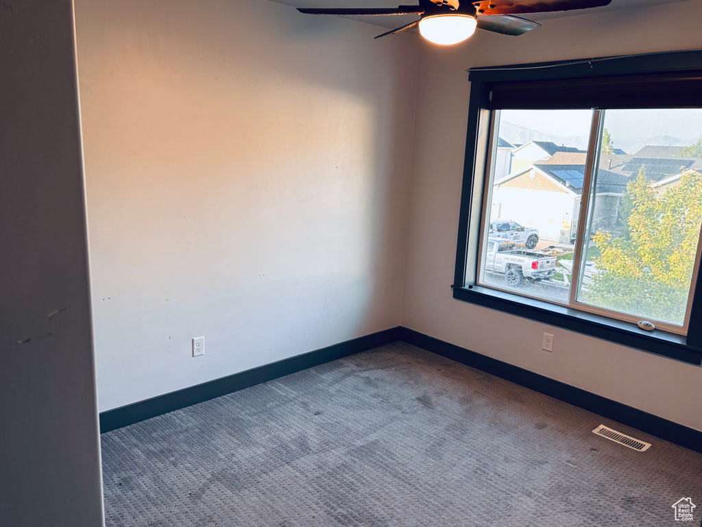 Spare room featuring a ceiling fan, carpet floors, and baseboards