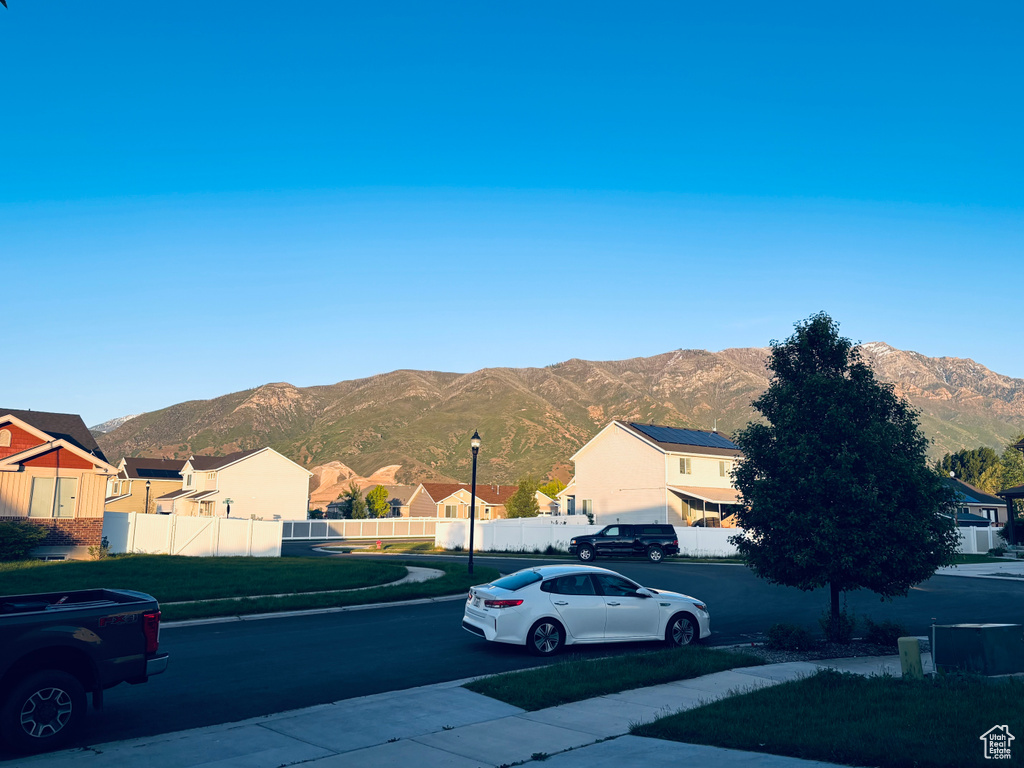 View of road with a mountain view, street lighting, a residential view, and sidewalks