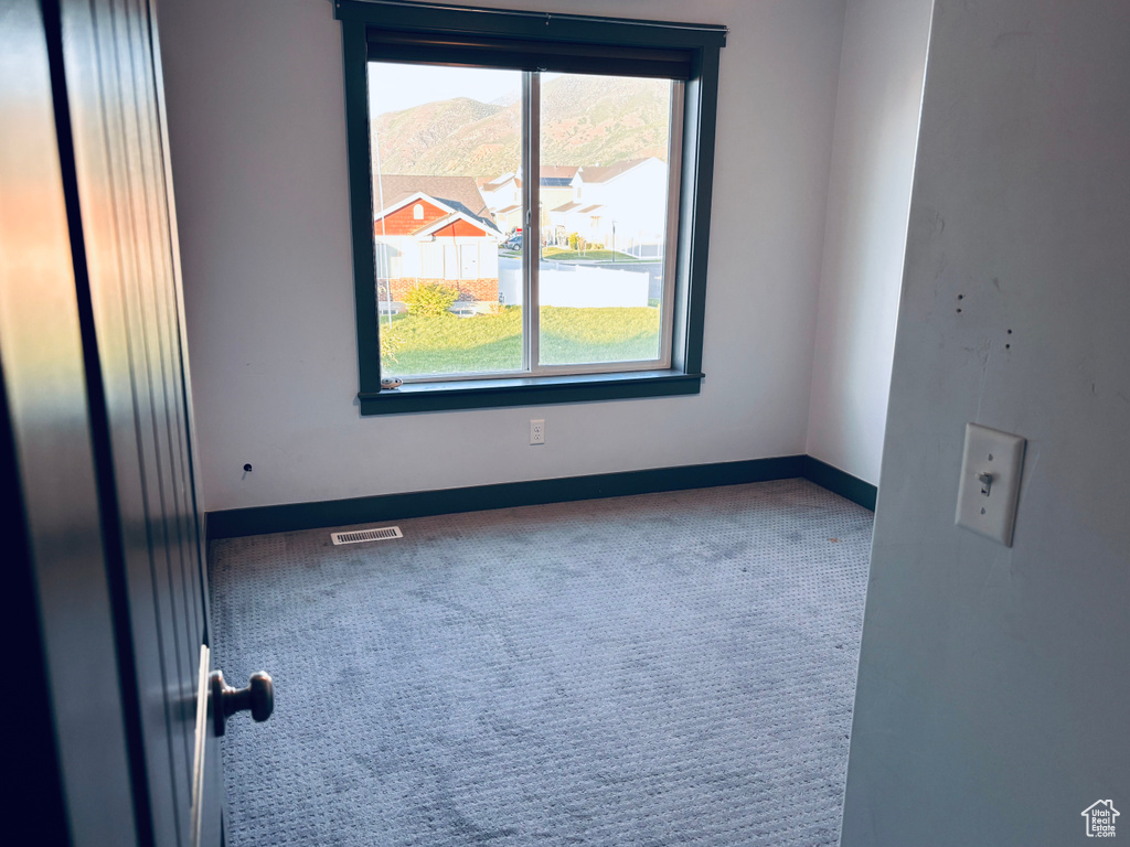 Unfurnished room featuring carpet floors and baseboards