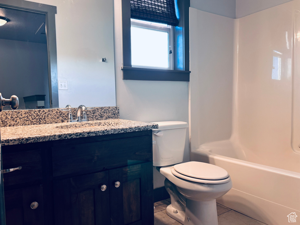 Full bath featuring vanity, toilet, shower / bath combination, and tile patterned floors