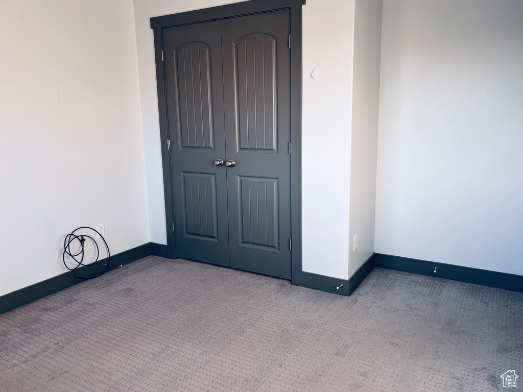Carpeted empty room with baseboards