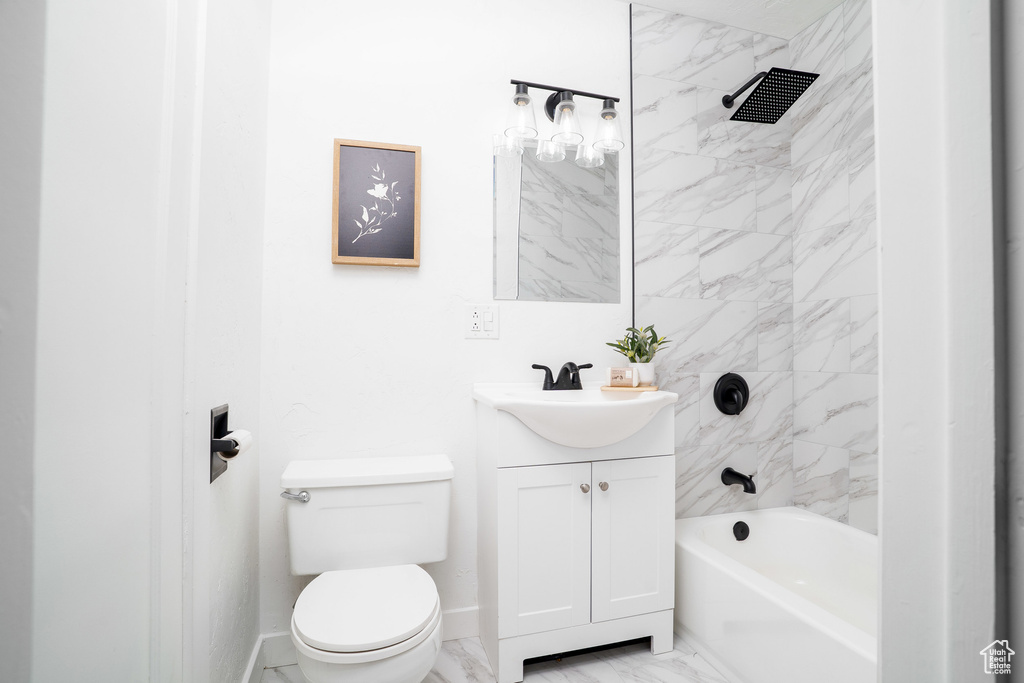 Bathroom with marble finish floor, toilet, vanity, and shower / tub combination