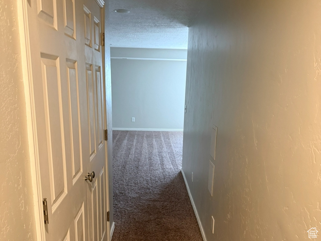 Hall featuring carpet flooring and baseboards