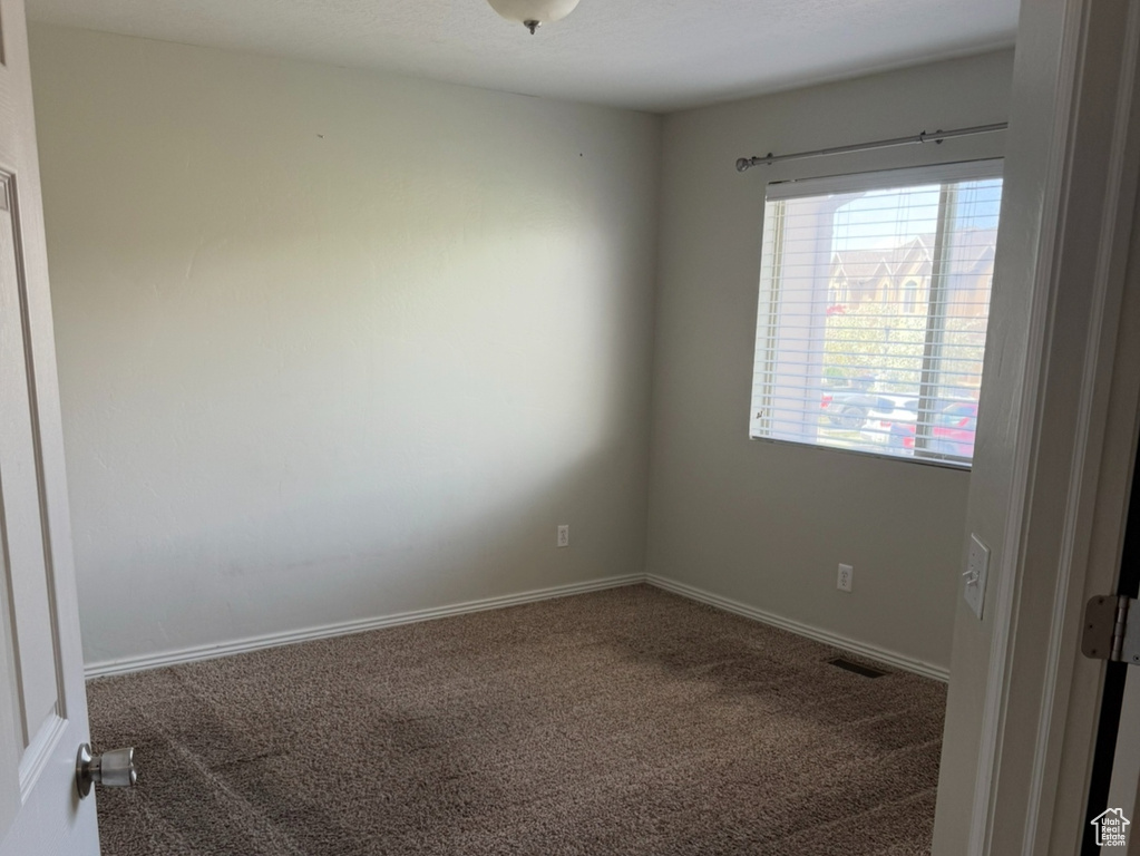Carpeted spare room with baseboards