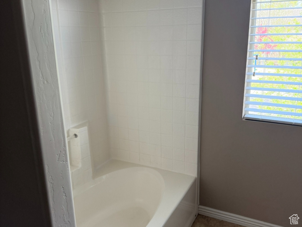 Bathroom featuring tub / shower combination, tile patterned floors, and baseboards