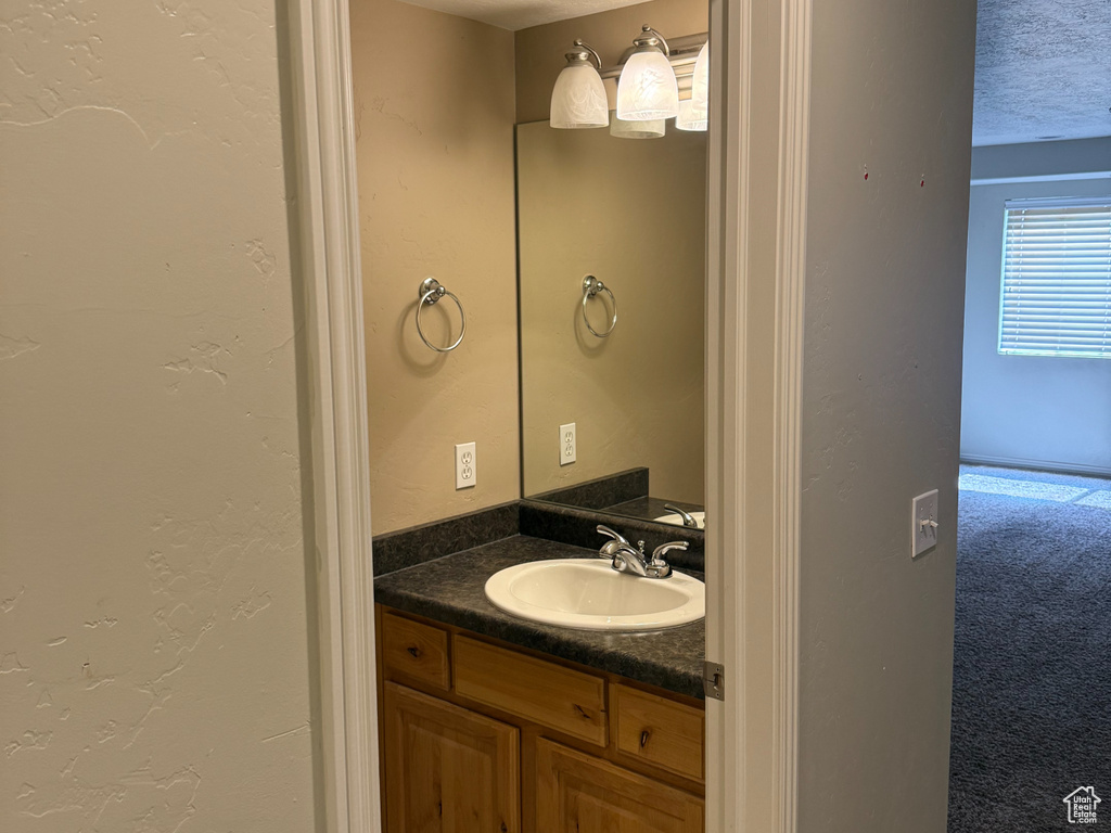 Bathroom featuring a textured ceiling, tile patterned floors, and vanity