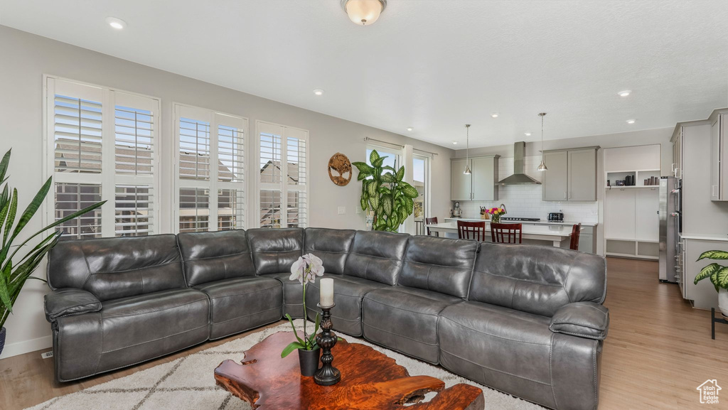 Living area featuring light wood finished floors, recessed lighting, and baseboards