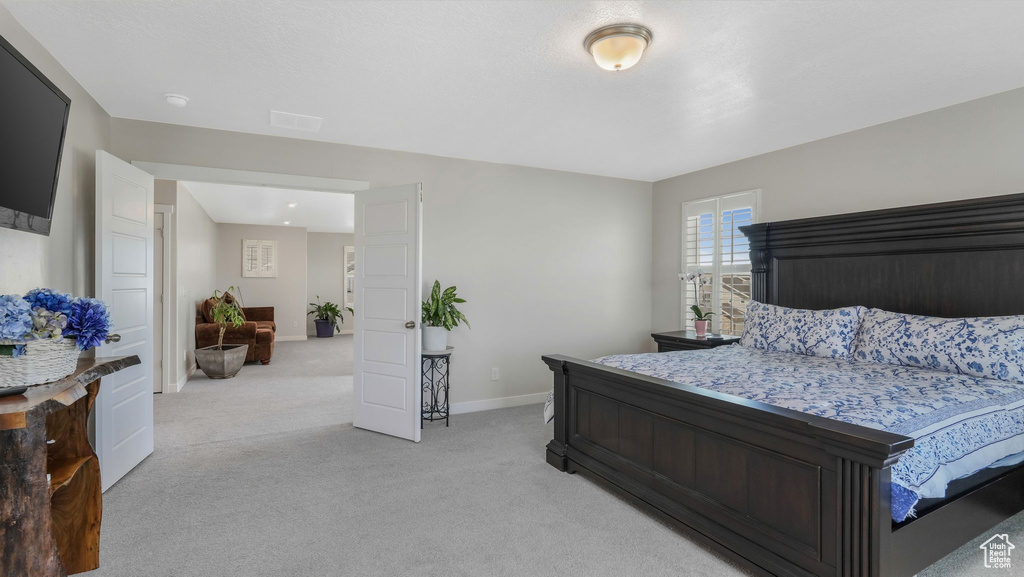 Bedroom featuring light colored carpet and baseboards