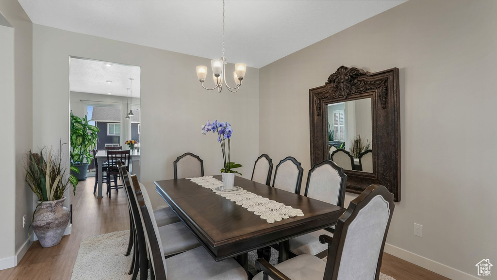 Dining room with baseboards, wood finished floors, and a chandelier