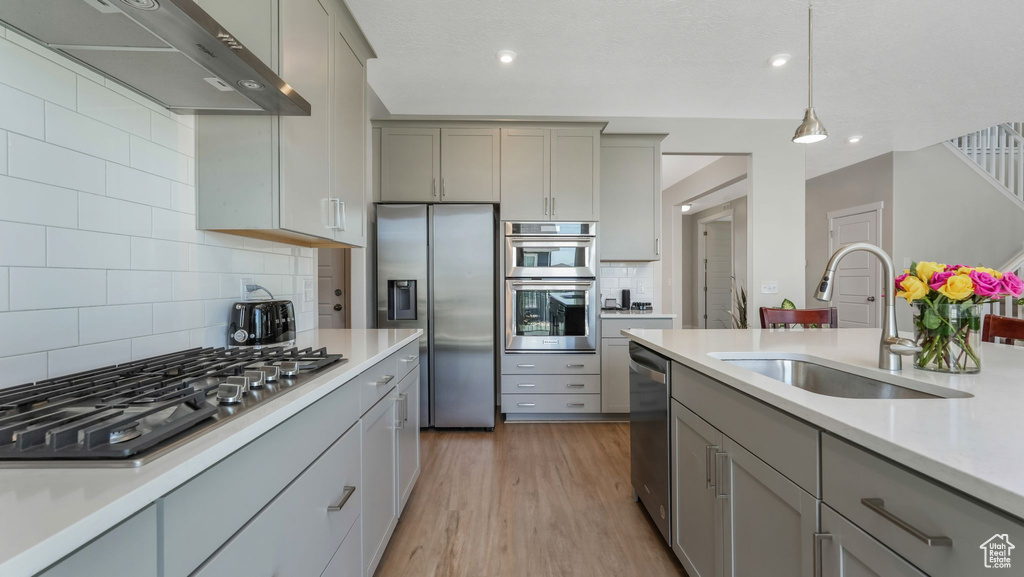 Kitchen with a sink, gray cabinets, and stainless steel appliances