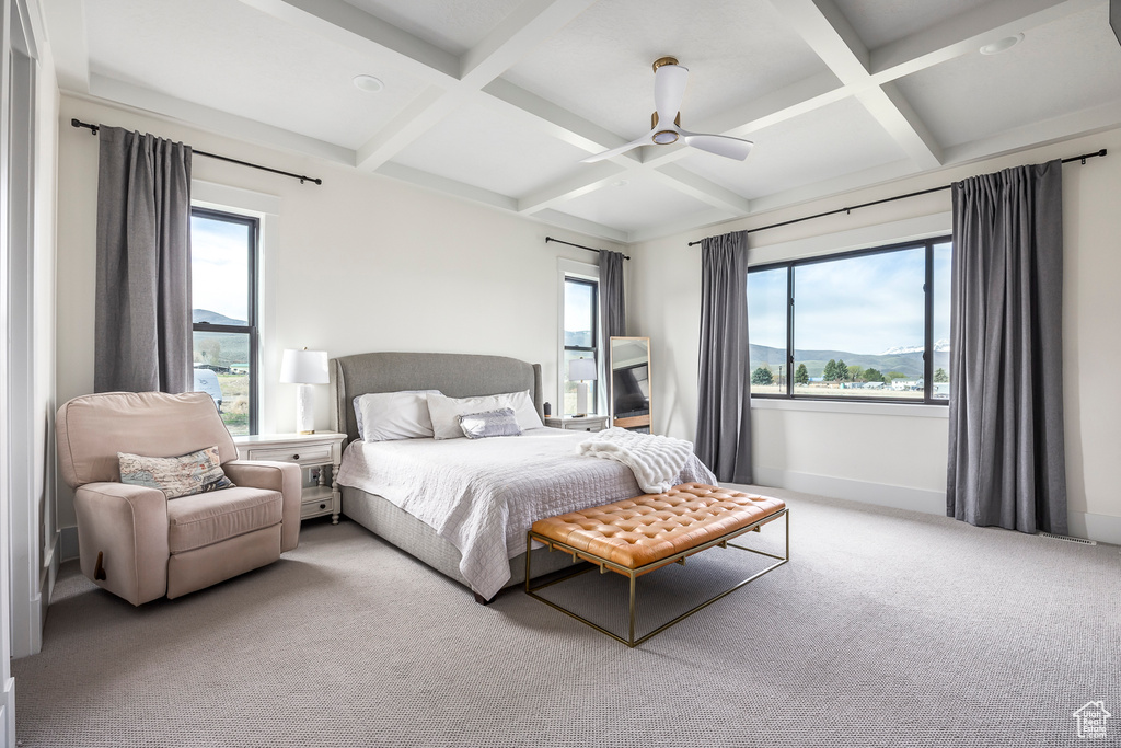 Carpeted bedroom with beam ceiling, coffered ceiling, and multiple windows