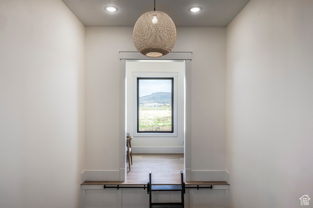 Stairway featuring baseboards, wood finished floors, and recessed lighting