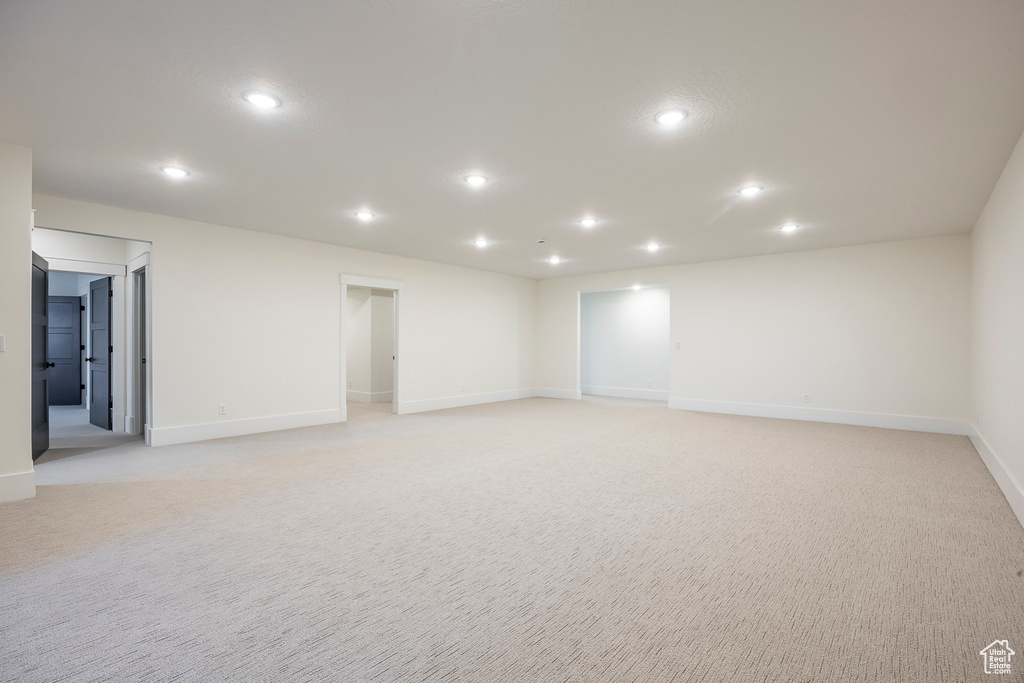Empty room featuring recessed lighting, baseboards, and light carpet