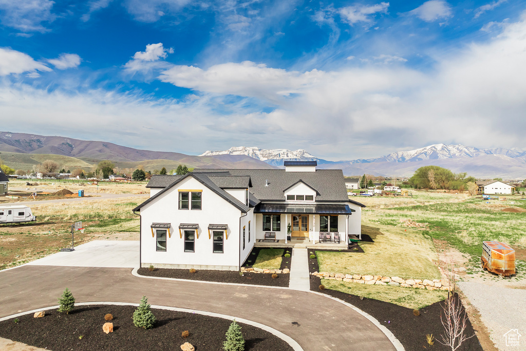 Modern farmhouse with roof with shingles, curved driveway, and a mountain view