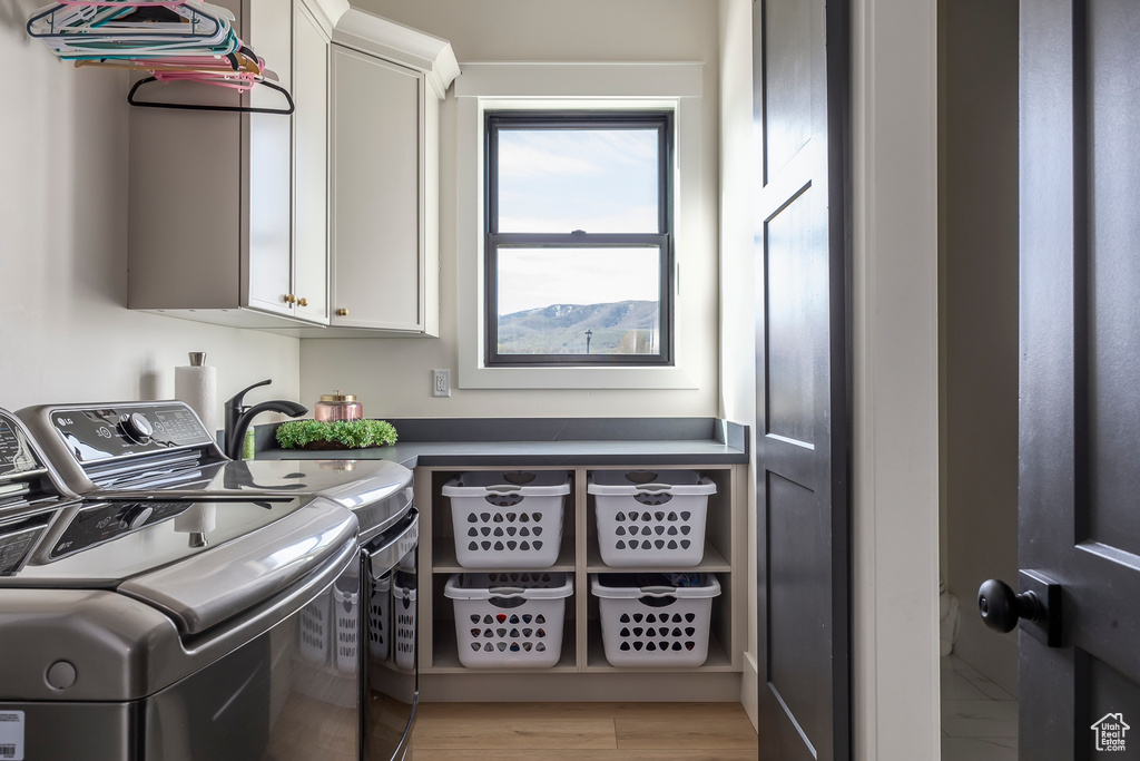 Laundry area with cabinet space and washing machine and clothes dryer
