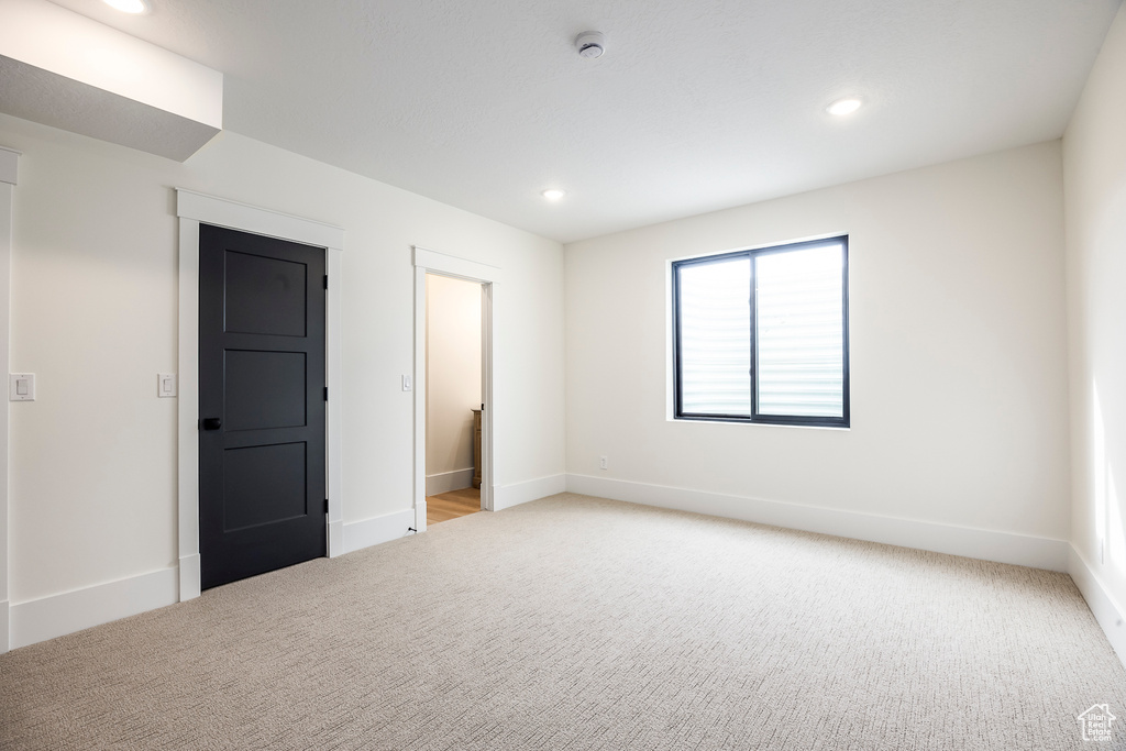 Empty room featuring recessed lighting, baseboards, and light colored carpet
