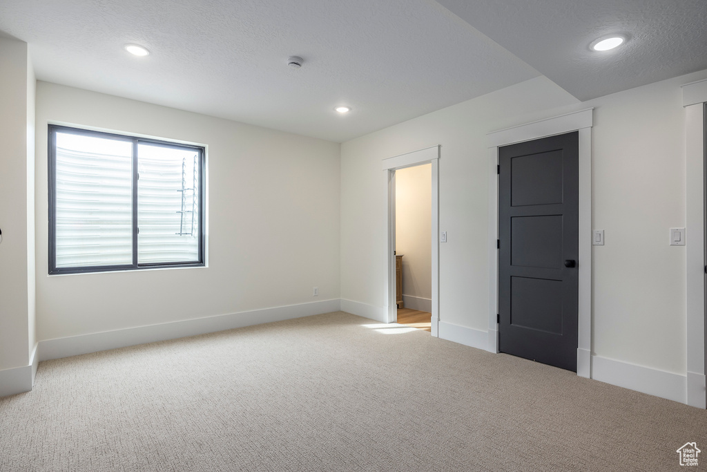 Carpeted spare room featuring recessed lighting and baseboards