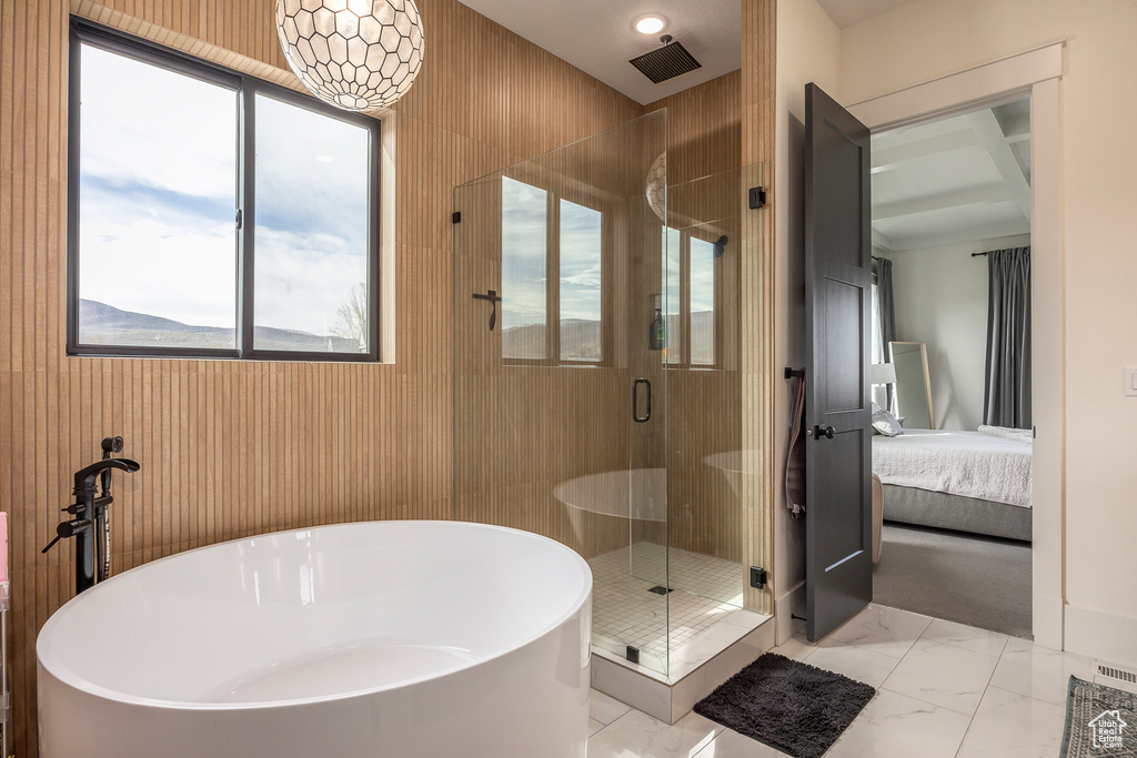 Ensuite bathroom featuring a freestanding tub, ensuite bath, marble finish floor, and a stall shower