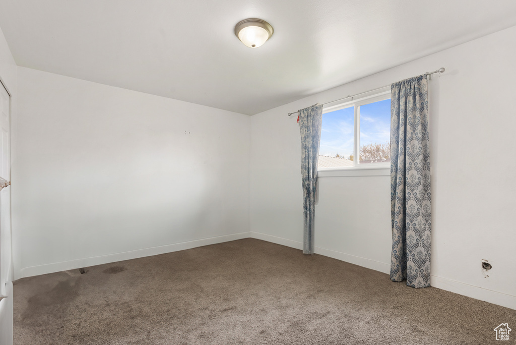 Empty room with carpet and baseboards