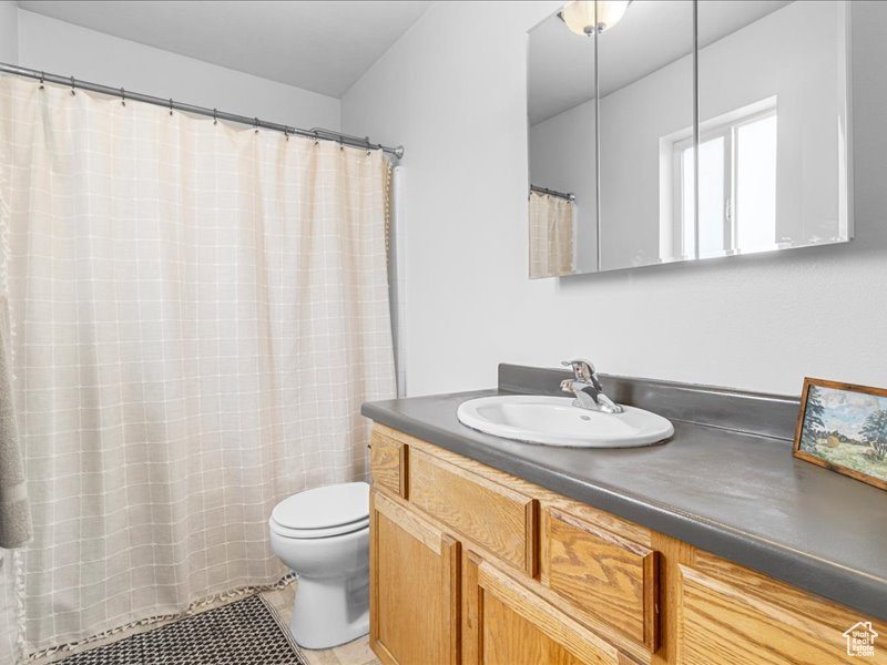 Bathroom featuring vanity, tile patterned flooring, and toilet