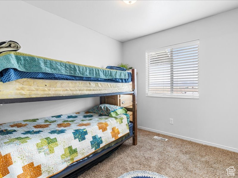 Bedroom featuring baseboards, visible vents, and carpet