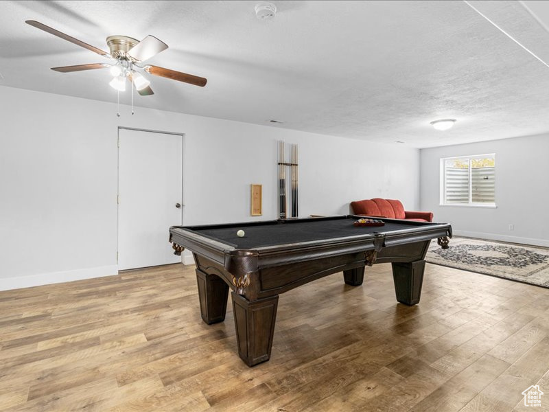 Game room with light wood-type flooring, baseboards, and billiards