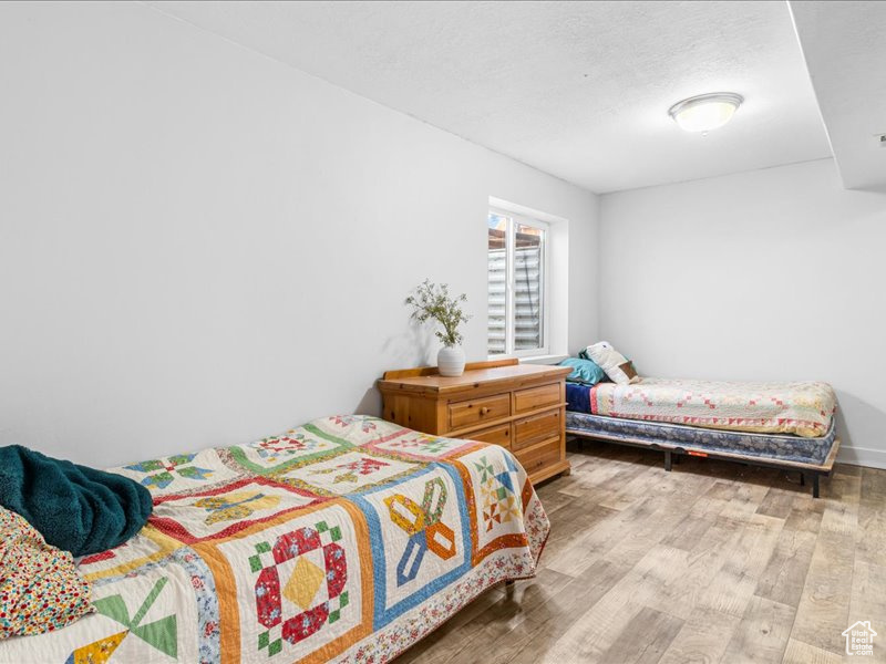 Bedroom featuring wood finished floors and a textured ceiling