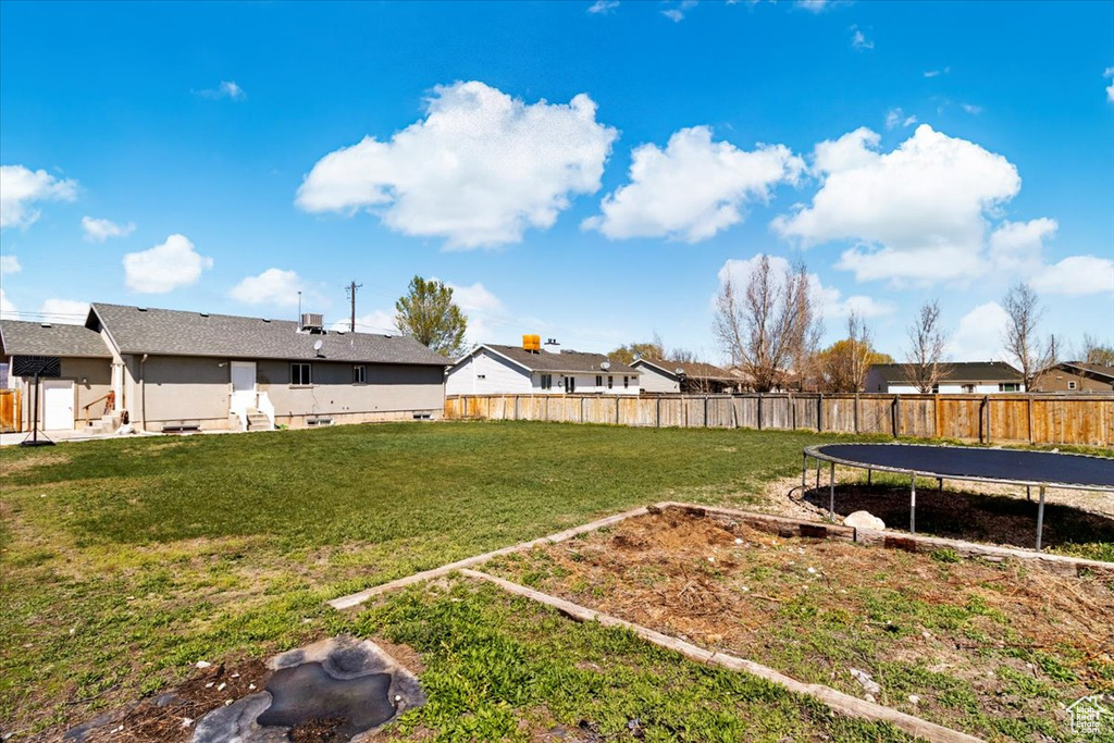 View of yard with fence and a trampoline