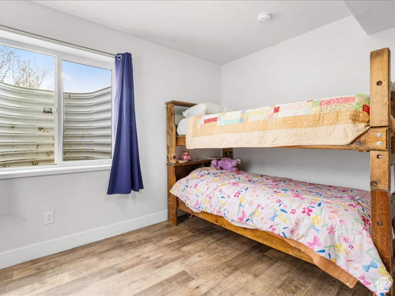 Bedroom with baseboards and wood finished floors