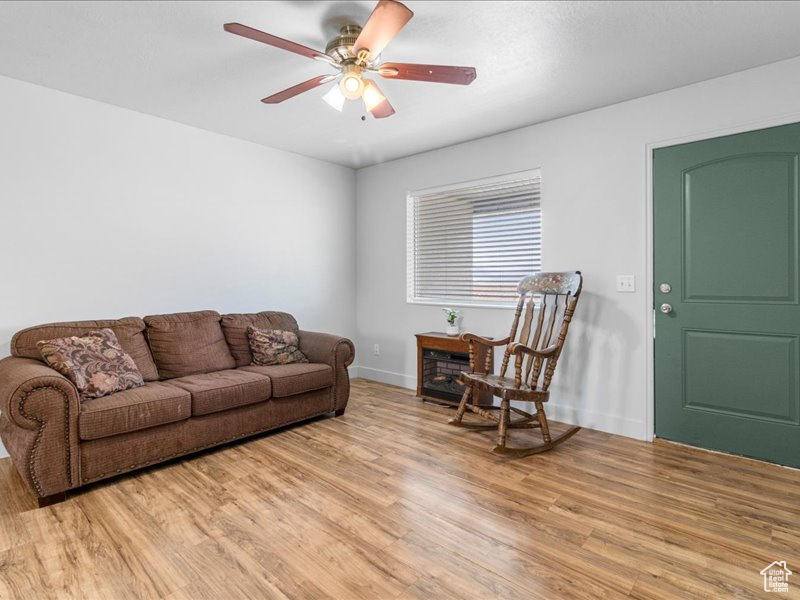 Living area featuring light wood finished floors, baseboards, and ceiling fan